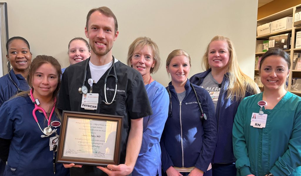 Dr. Iain Charnley, holding his award, and his medical staff.